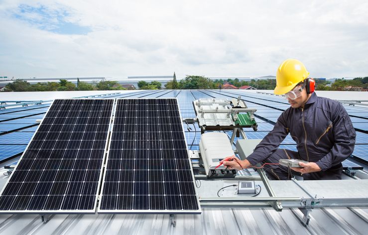 A professional repairing solar panels on a rooftop in Atlanta, GA